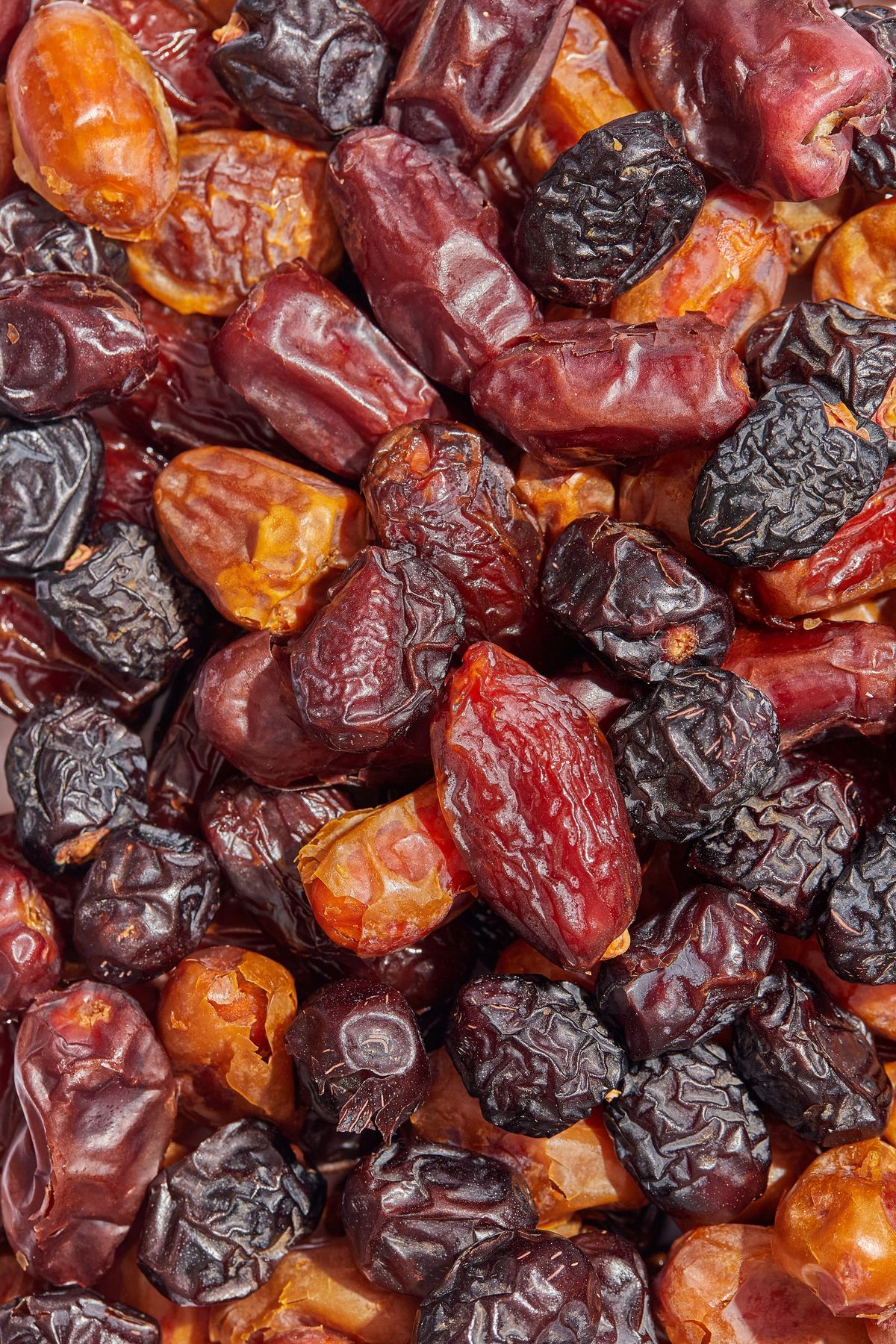A close-up pile of mixed dates, from amber to near-black