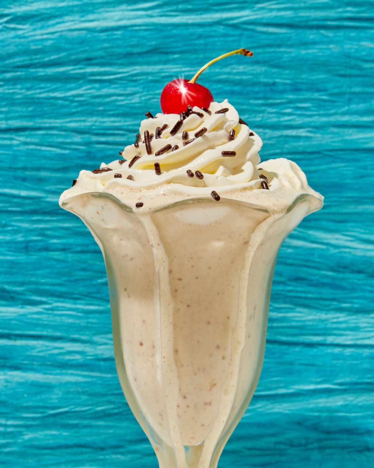 A date shake topped with whipped cream and a cherry